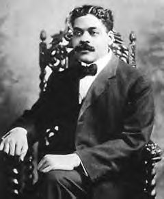 A black and white portrait of Arturo Schomburg